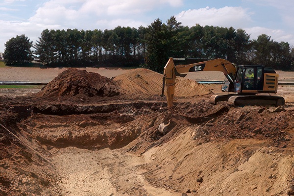 Excavator digging a trench in the dirt