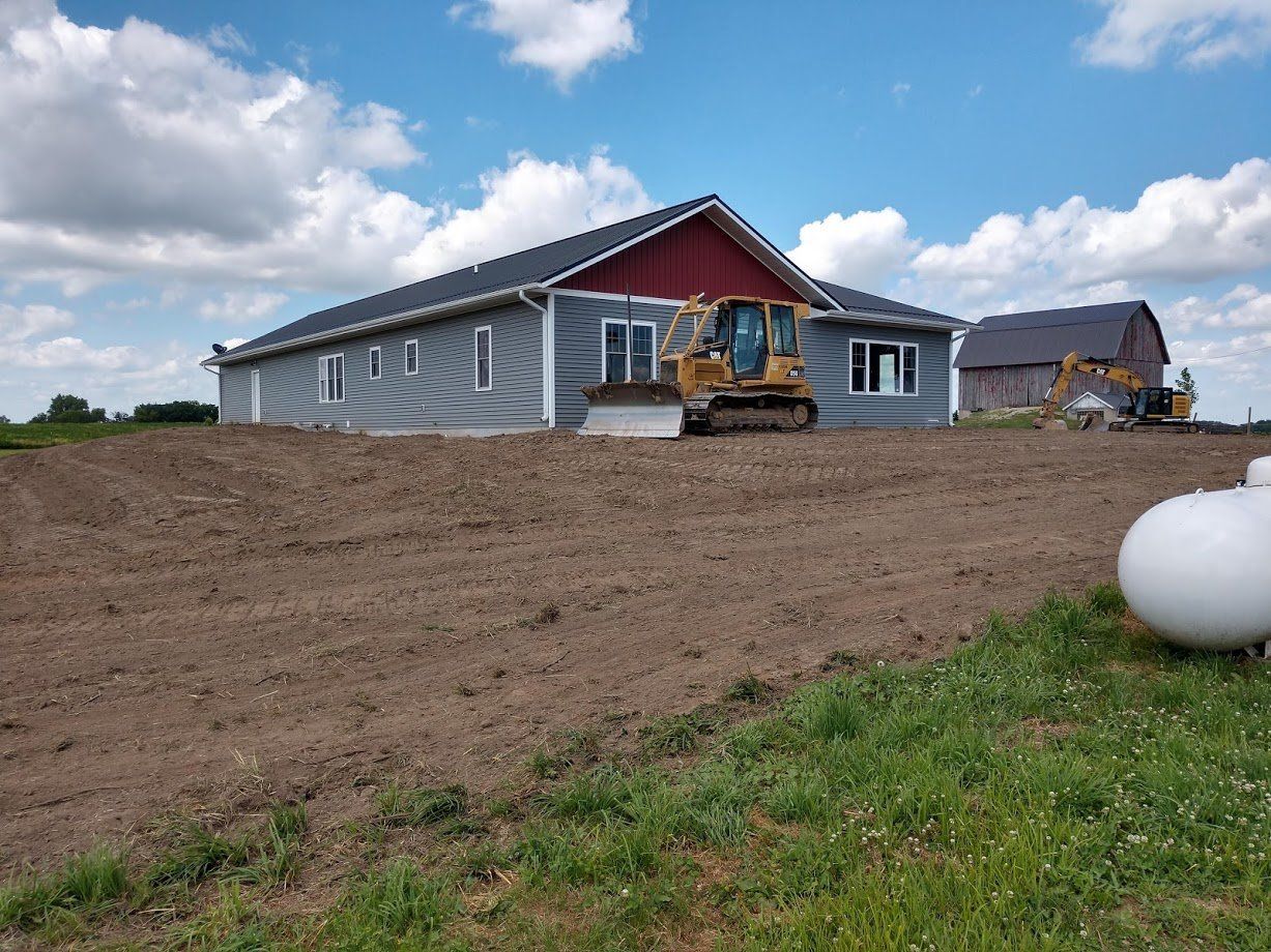 Bulldozer moving dirt around a farm house