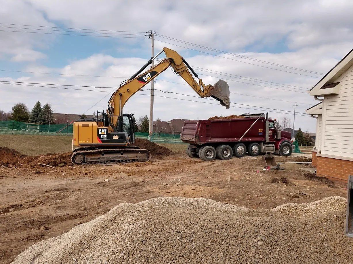 Excavator filling a truck with dirt